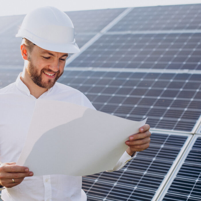 Young architect standing by solar panels